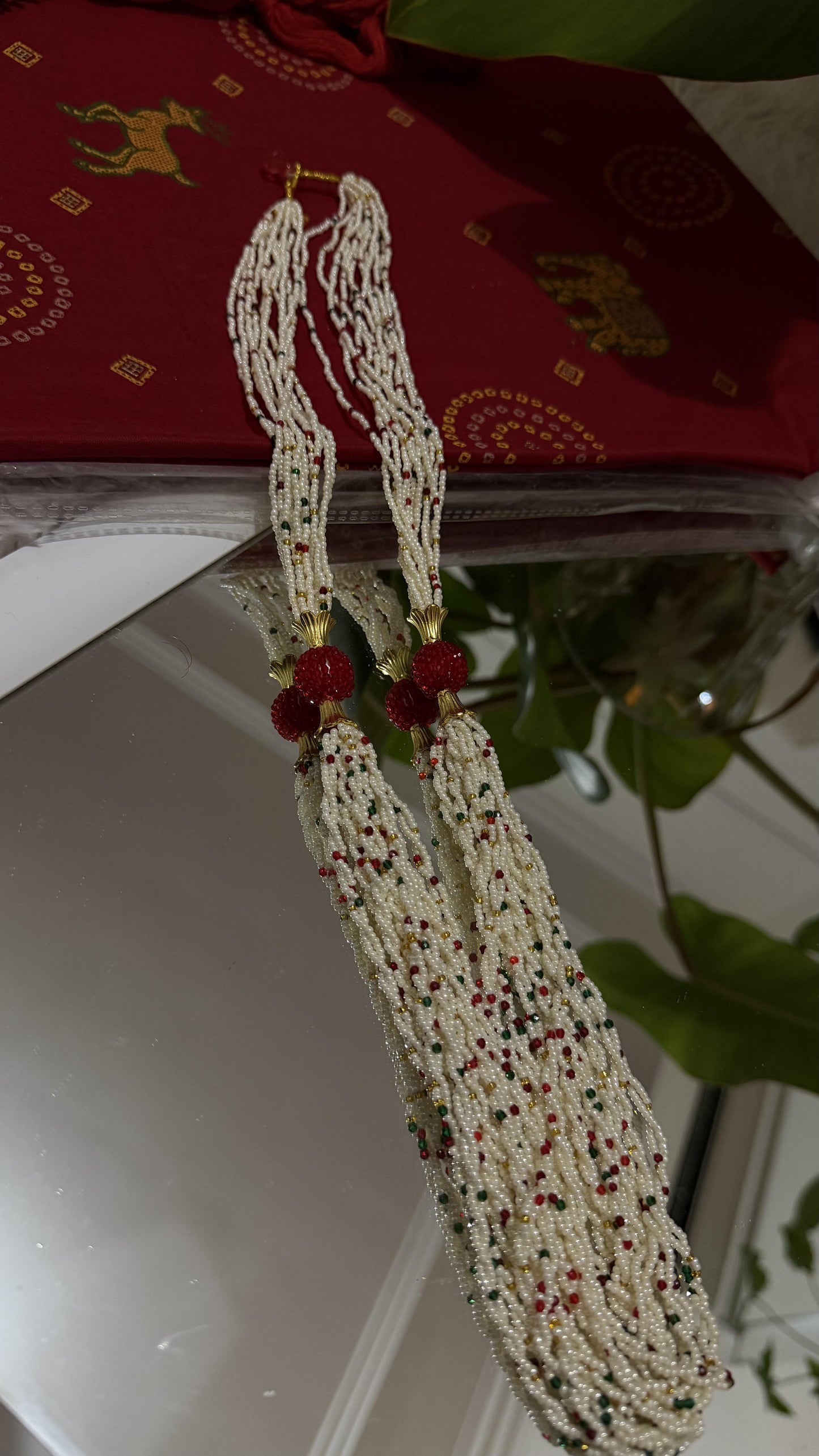 Ivory multi-strand seed pearl necklace with ruby red emerald green beads and gold-plated carved centre ball — Behuli — view 2