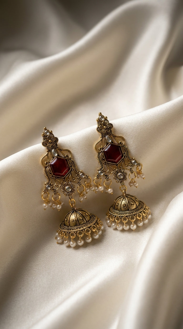 Antique gold jhumka earrings with ruby hexagonal stone, pearl drops and engraved bell dome on ivory silk — Behuli Australia
