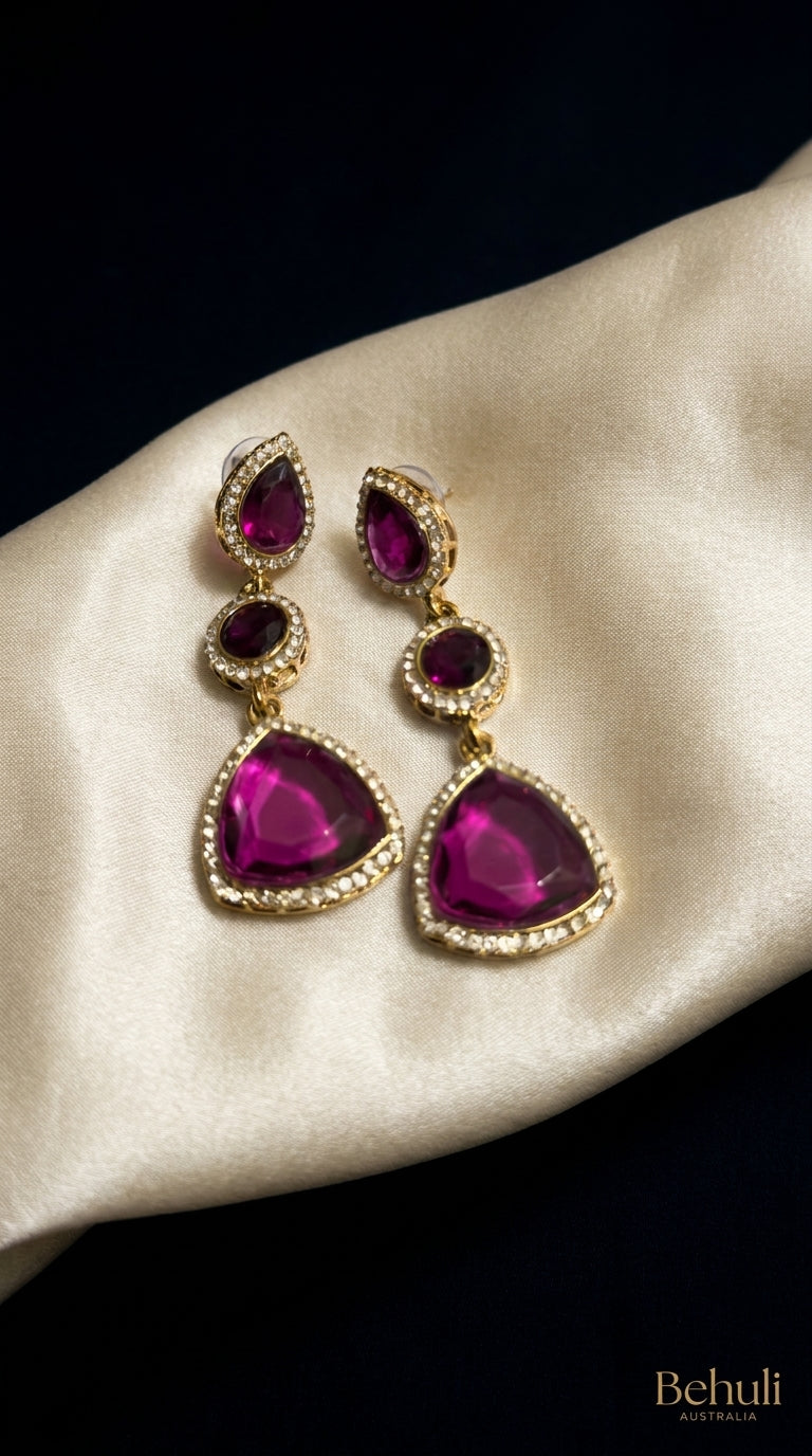 Fuchsia three-tier drop earrings with crystal halo borders and gold-toned setting displayed on ivory satin — Behuli Australia