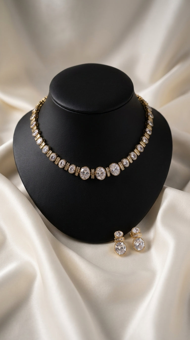 Gold-tone necklace and earrings set with oval clear stone embellishments displayed on black bust — Behuli Australia
