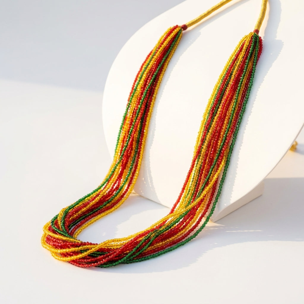 Multi-strand tri-colour red yellow and green seed bead statement necklace displayed on white stand — Behuli Australia