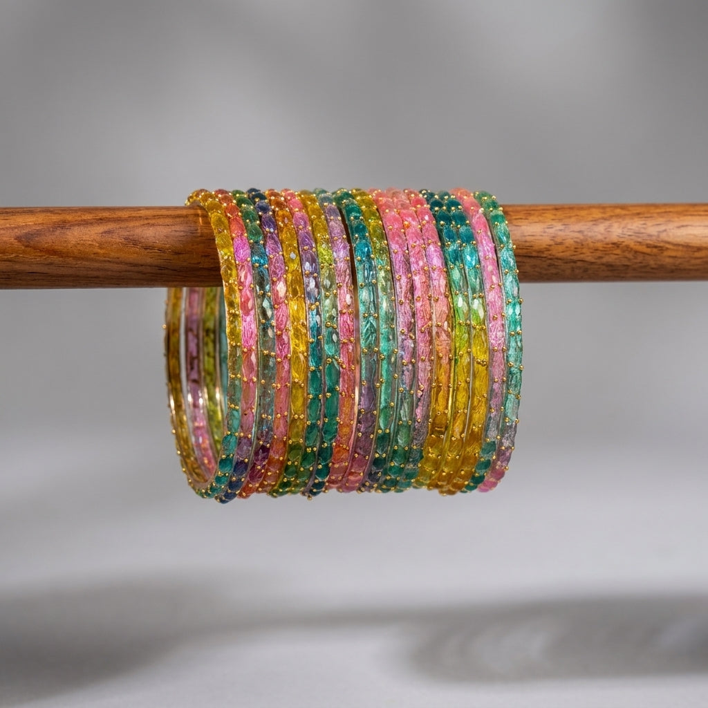 Multicolour glass bangles with gold bead embellishment in teal pink yellow green stacked on wooden rod — Behuli Australia