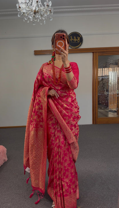 Fuchsia Banarasi silk saree with all-over gold zari floral weave and broad zari border, styled with matching full-sleeve