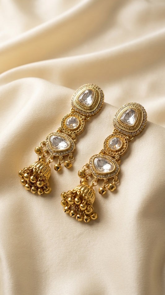 Gold-plated Kundan jhumka earrings with three polki crystal stones and ghungroo bell cluster drops on cream silk — Behuli