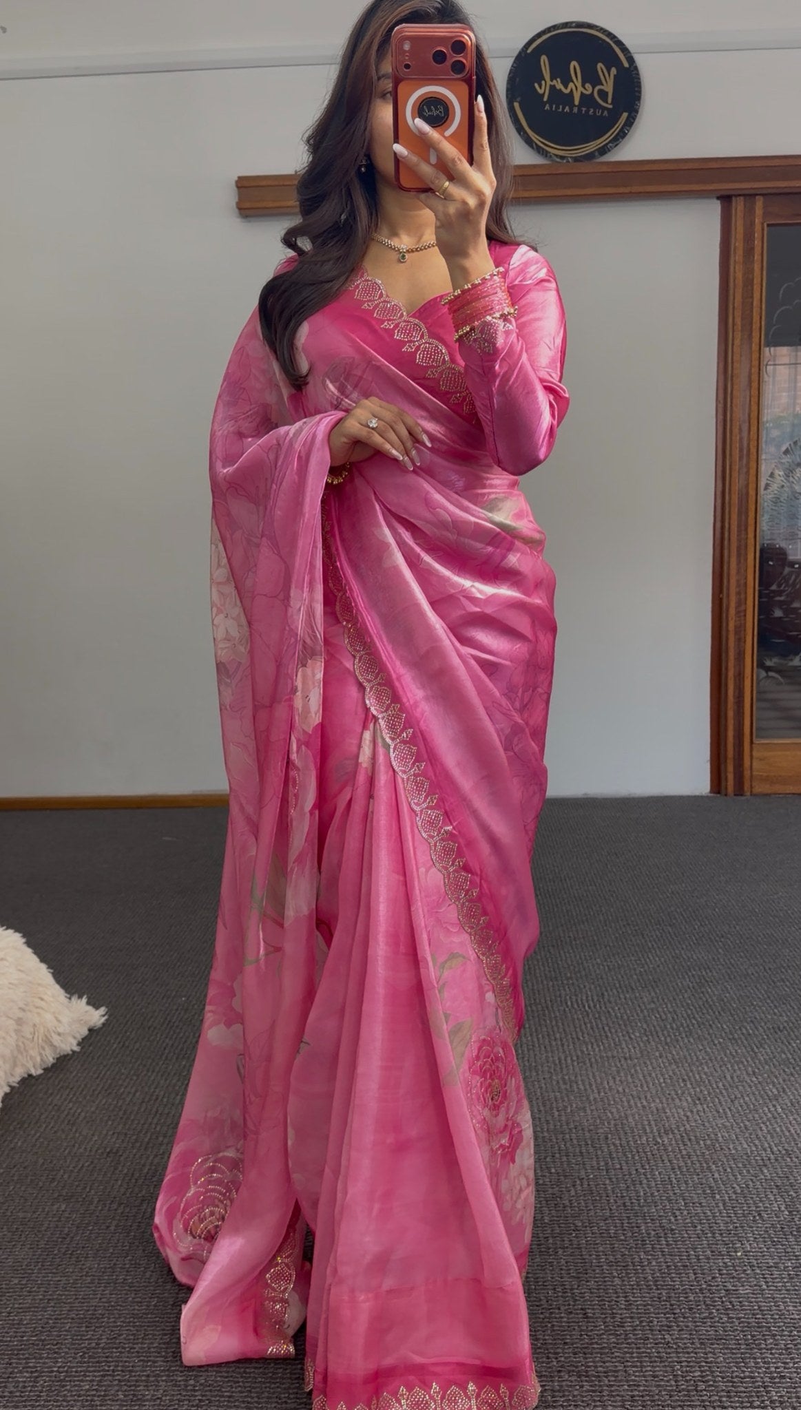 Pink floral printed saree with gold sequin border detailing and matching embroidered blouse draped elegantly