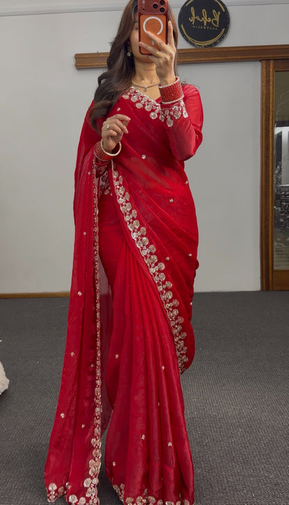 Red saree with silver sequin floral embroidery on border and pallu, draped with matching full-sleeve blouse