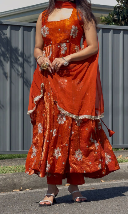 Rust orange Anarkali gown with ivory and gold circular floral embroidery, styled with gold choker and jhumka earrings — — view 4