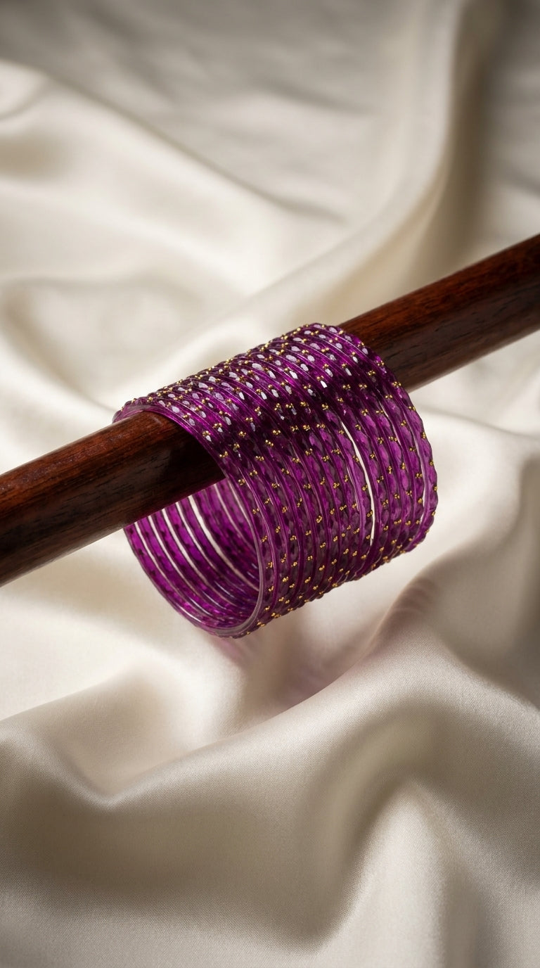 Deep purple 12-piece glass bangles with gold dot detailing displayed on a wooden rod — Behuli Australia