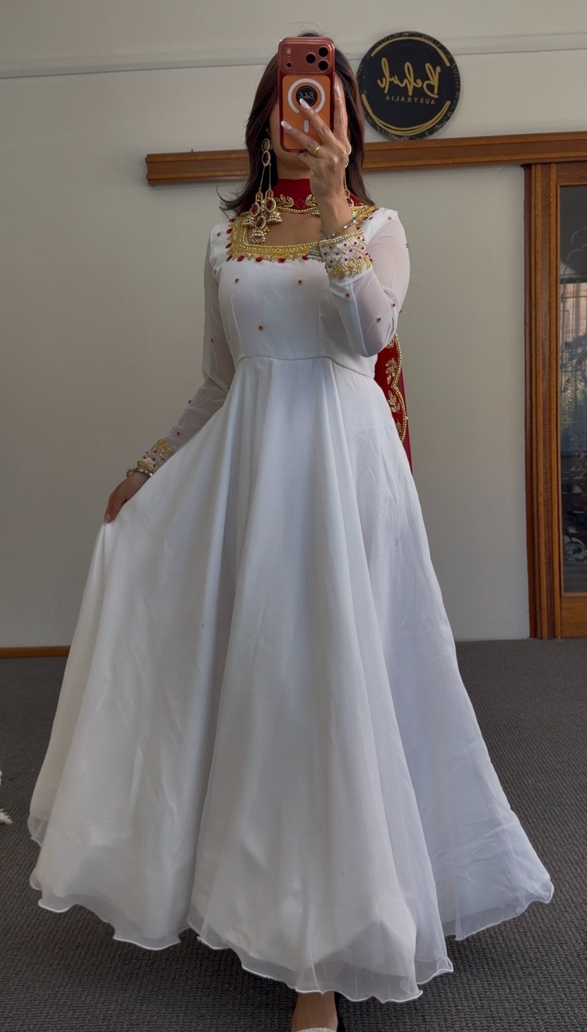 White flared Anarkali gown with deep red yoke, gold zari-style border embroidery and scattered stone embellishments — Behuli