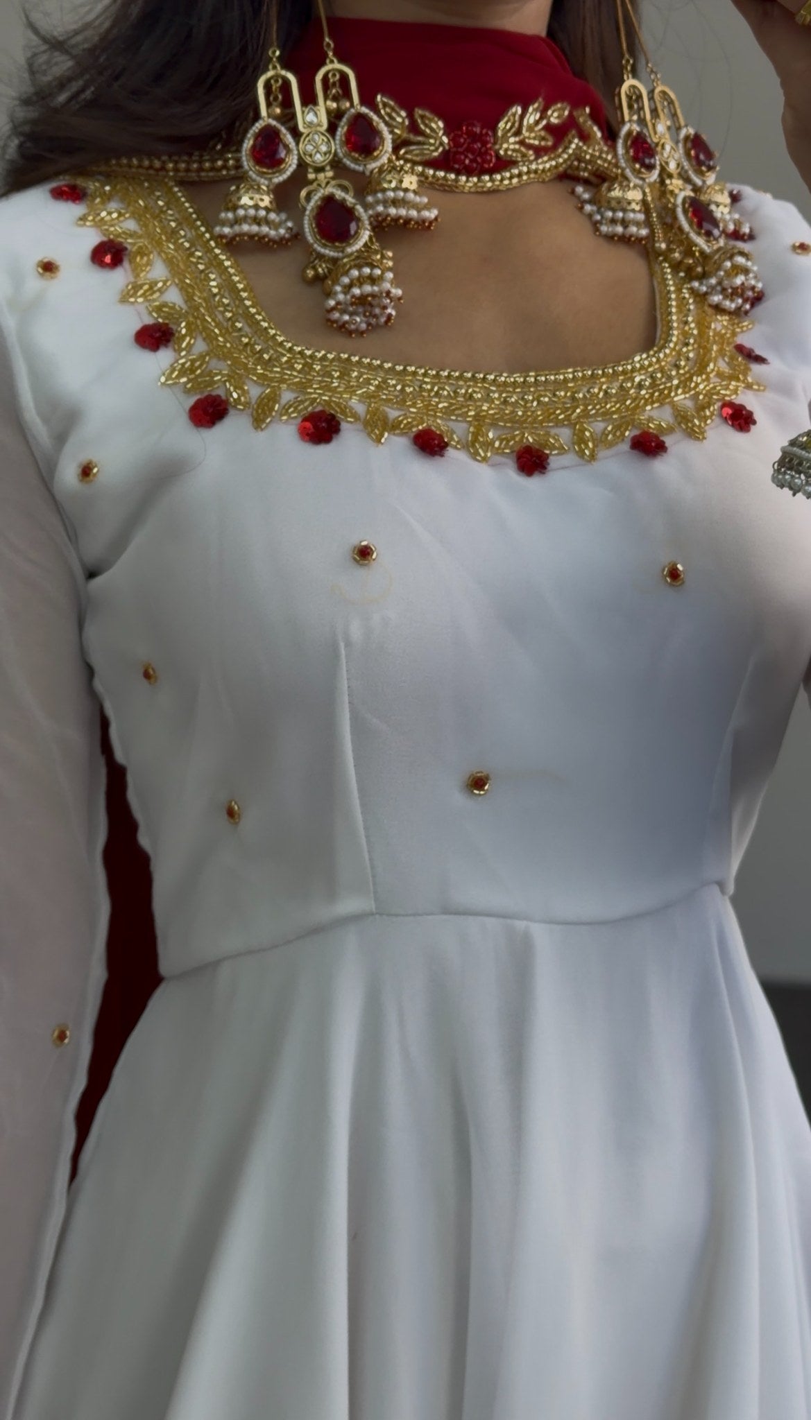 White flared Anarkali gown with deep red yoke, gold zari-style border embroidery and scattered stone embellishments — Behuli — view 2