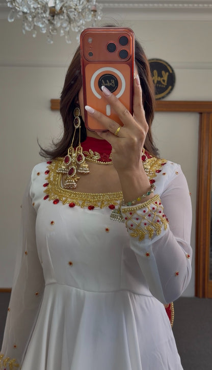 White flared Anarkali gown with deep red yoke, gold zari-style border embroidery and scattered stone embellishments — Behuli — view 3