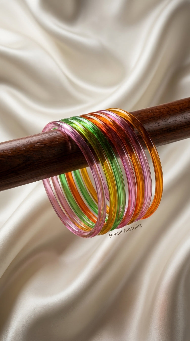Set of 8 multicolour glossy bangles in pink, green and orange displayed on wooden rod — Behuli Australia