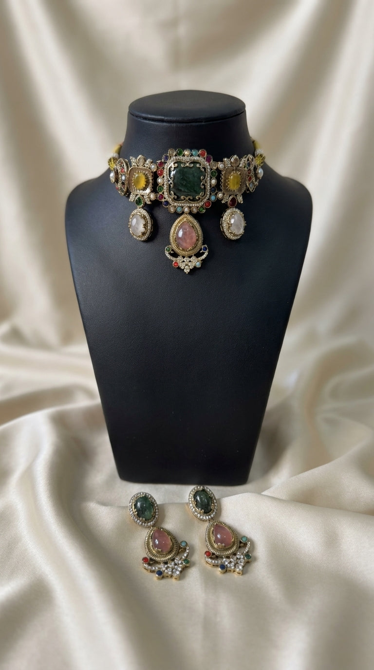 Antique gold jewellery set with green, pink and yellow stones, pearl detailing and matching statement earrings on black — view 2