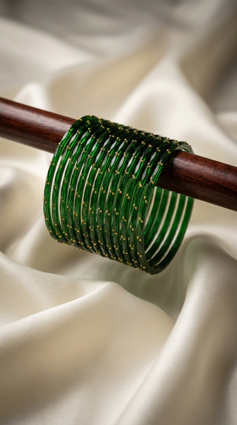 Stack of emerald green bangles with gold bead detailing displayed on a wooden rod — Behuli Australia festive jewellery