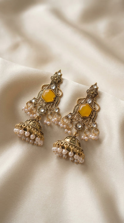 Antique gold jhumka earrings with mustard hexagonal stone centrepiece, floral filigree and ivory pearl-style bead drops —