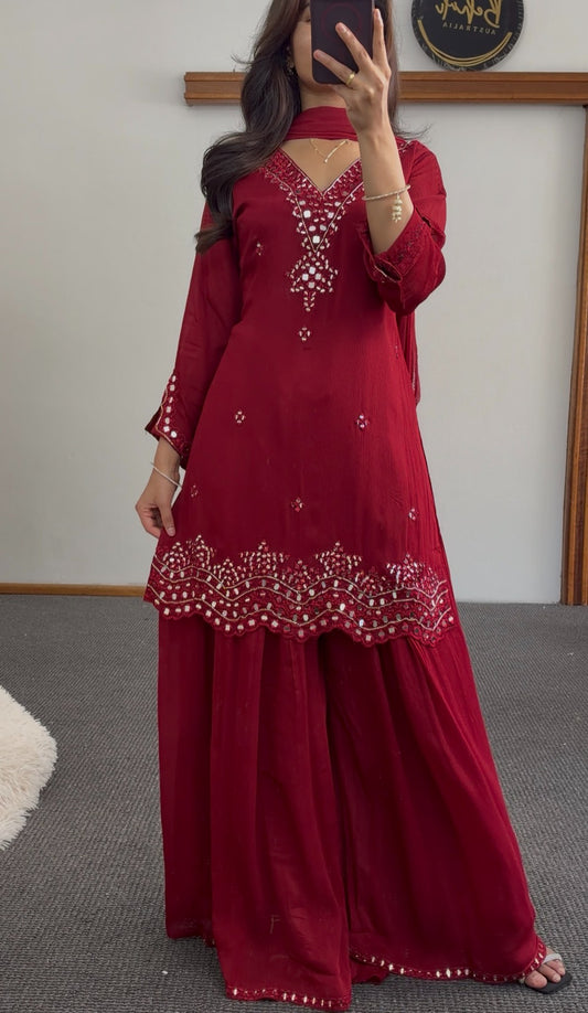 Maroon palazzo suit set with mirror work embroidery, scalloped hemline and matching dupatta worn by a model