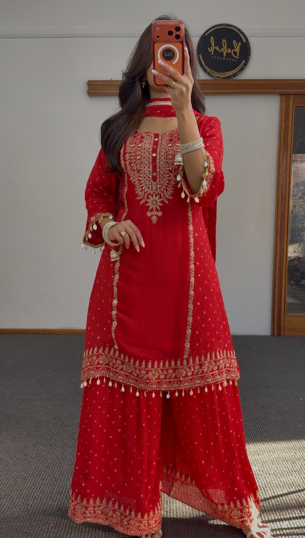 Deep red sharara anarkali suit with gold zari embroidery, woven buti pattern and pearl-drop tassels — Behuli Australia