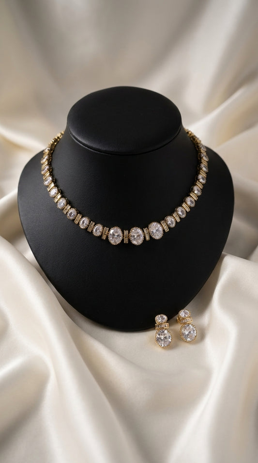 Gold-tone necklace and earrings set with oval clear stone embellishments displayed on black bust — Behuli Australia