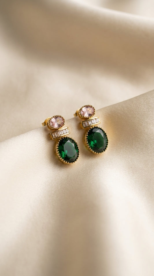 Gold-tone jewellery set with emerald green and pink stones, necklace on black display bust with matching earrings — view 2