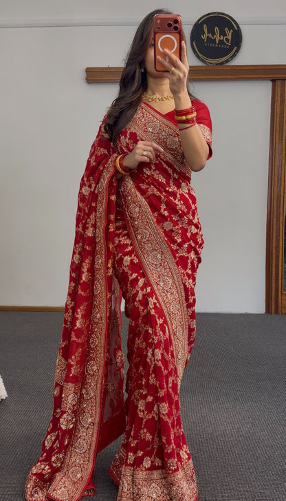 Red khaddi georgette saree with gold zari embroidery and floral border design worn with matching red blouse