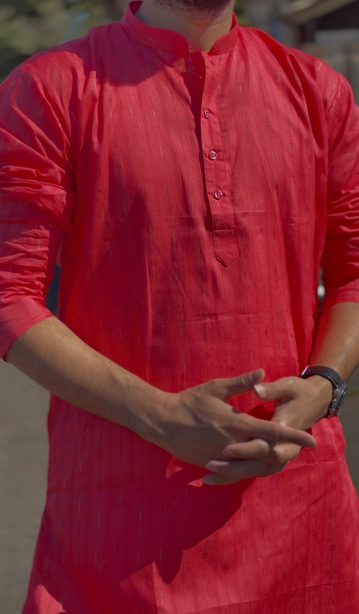 Man wearing a red mandarin collar kurti with subtle woven texture and white trousers, standing outdoors — view 3