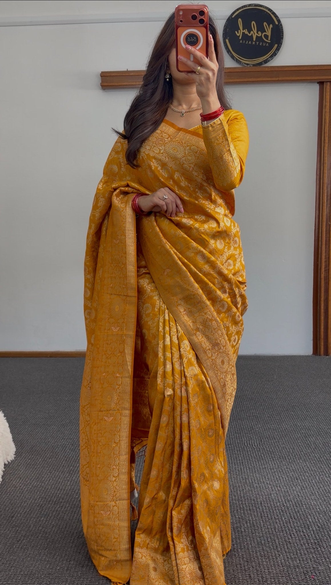 Mustard yellow saree with woven gold zari floral motifs and matching long-sleeve blouse draped elegantly