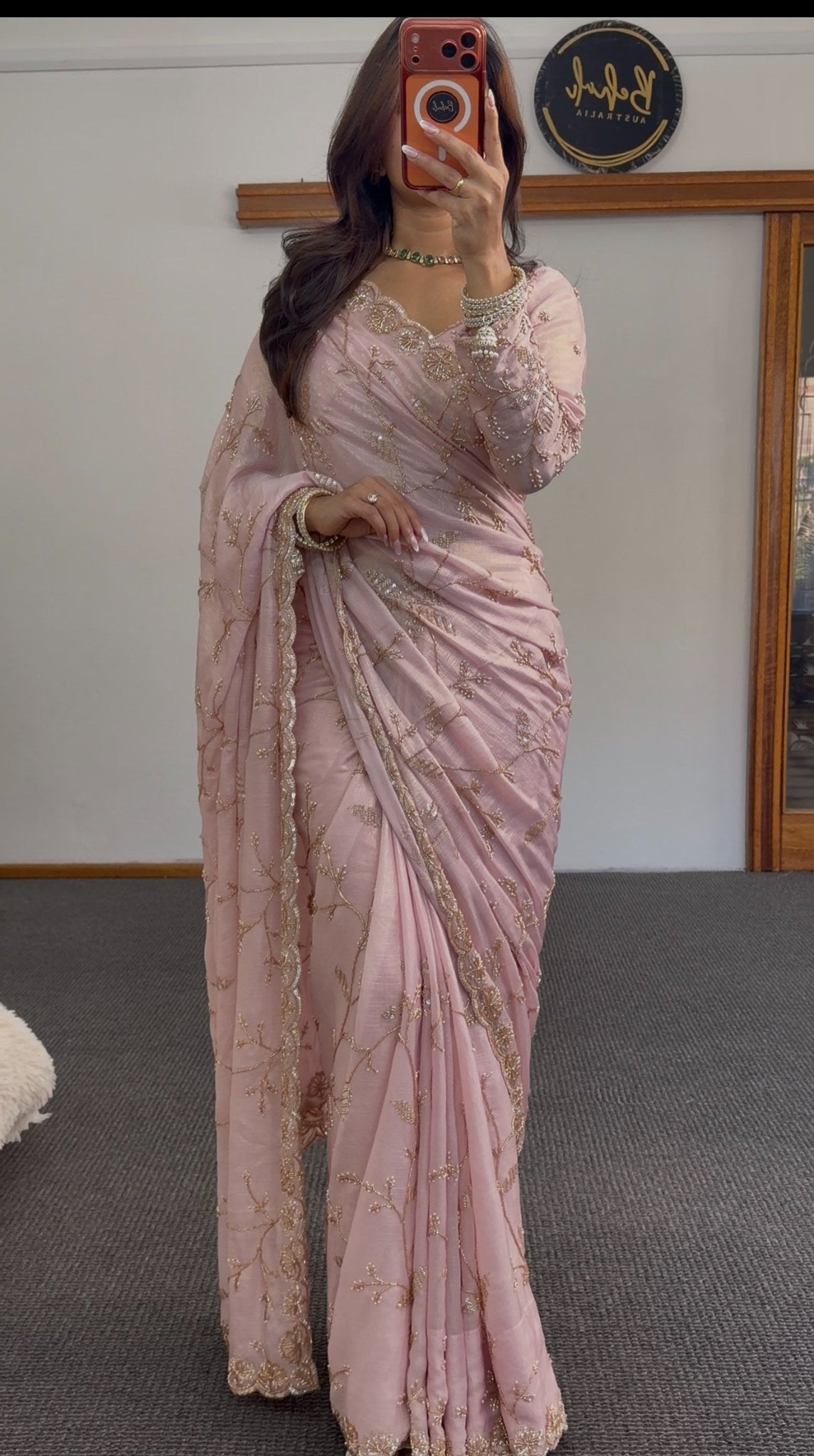 Blush pink chiffon saree with gold sequin embroidery and scalloped border draped in traditional style