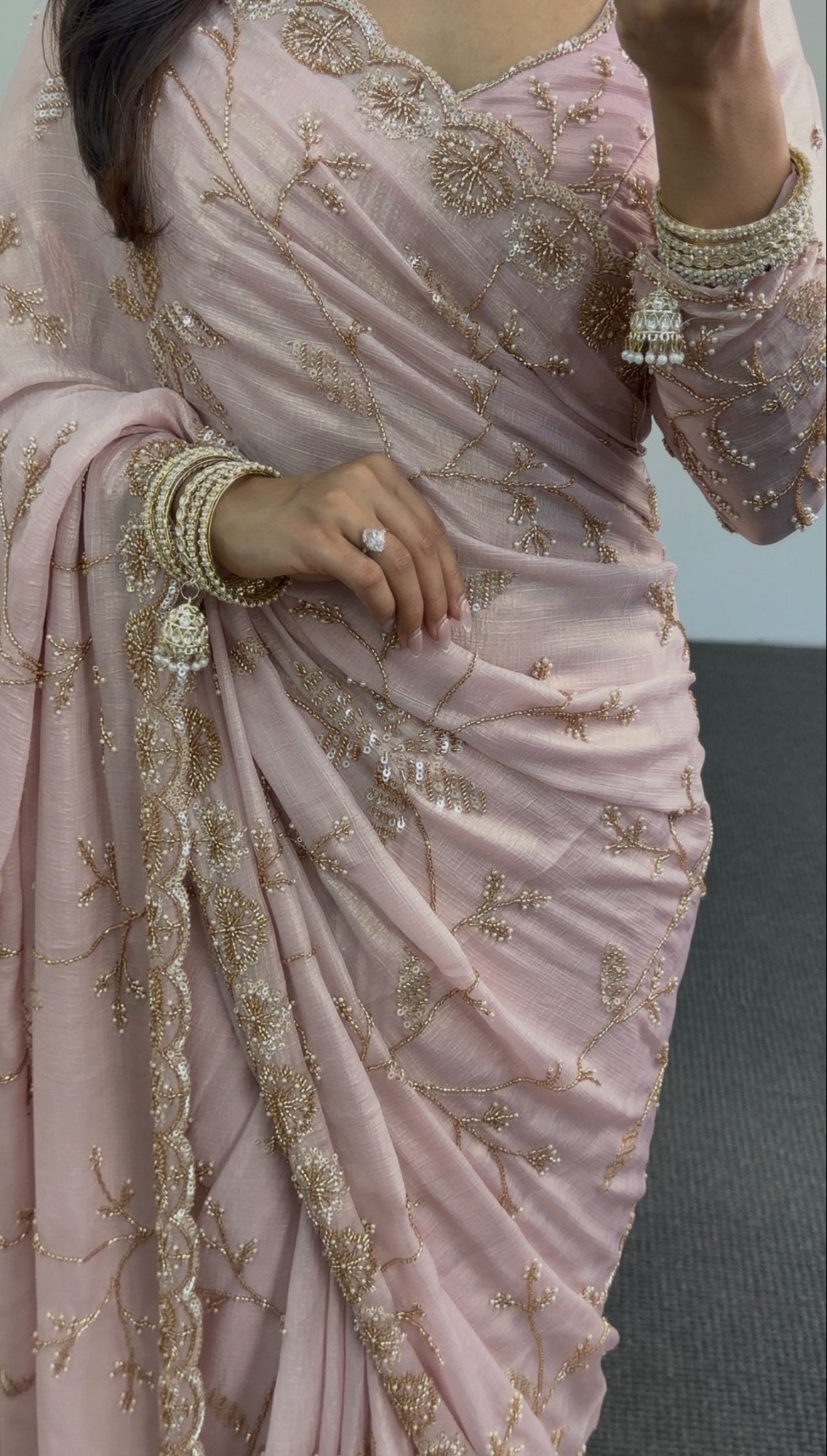 Blush pink chiffon saree with gold sequin embroidery and scalloped border draped in traditional style — view 3
