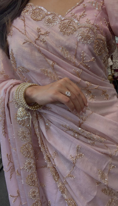 Blush pink chiffon saree with gold sequin embroidery and scalloped border draped in traditional style — view 4