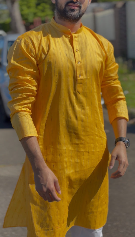 Mustard yellow men's kurti with mandarin collar and subtle self-striped texture, full sleeves, worn outdoors