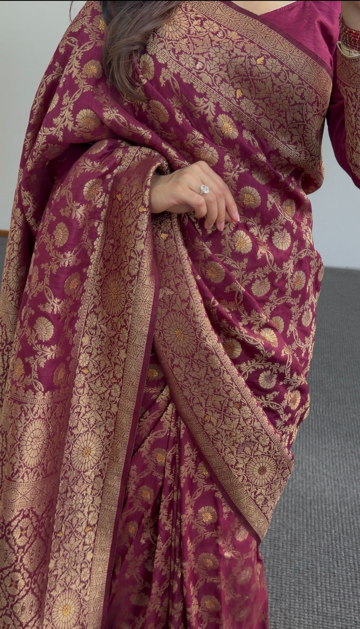 Maroon saree with gold zari floral weave, pallu draped over shoulder, worn with matching maroon blouse — view 4
