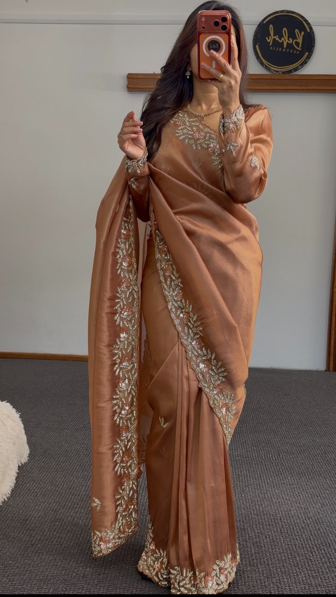 Copper satin saree with floral embroidered border and sequin detailing draped over shoulder — Behuli Australia